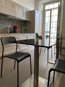 a kitchen with a glass table and chairs in it at Viva Accomodation in Bergamo +14 photos