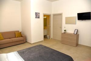 a living room with a couch and a flat screen tv at Dimora Borbonica 1 in Marcianise