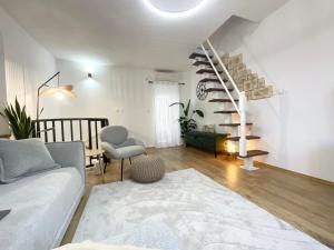 a living room with a couch and a spiral staircase at St Peter's Heritage House in Trogir