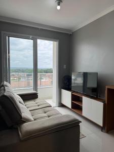a living room with a couch and a television at Apartamento confortável em Santarém in Santarém