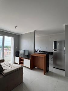a kitchen with a stainless steel refrigerator and a couch at Apartamento confortável em Santarém in Santarém