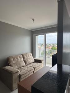 a living room with a couch and a large window at Apartamento confortável em Santarém in Santarém