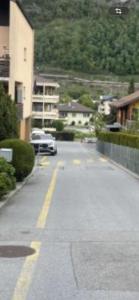 a street with a white car driving down a street at Studio My Home in Brig