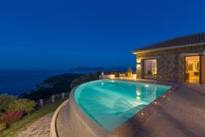 a swimming pool in front of a house at Olivia's Villas of Luxury in Skiathos Town