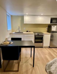 a kitchen with a table and a sink and a stove at Studio moderne et tranquille in Montreal