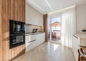 a kitchen with white cabinets and a view of the ocean at The Ultimate Jacuzzi Penthouse by PS in Durrës