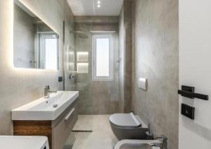 a bathroom with a sink and a toilet and a mirror at The Ultimate Jacuzzi Penthouse by PS in Durrës +35 photos