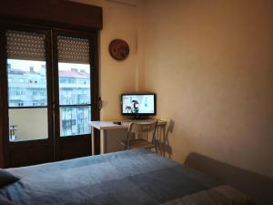a bedroom with a bed and a desk with a television at Amadora Pet Apartment in Amadora
