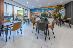 a restaurant with tables and chairs and a mural at Hotel MM Residence in Mostar
