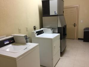 a kitchen with a stove and a refrigerator at Pearsall Inn and Suites in Pearsall