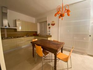eine Küche mit einem Holztisch und orangefarbenen Stühlen in der Unterkunft Rainerio 06 in Fano