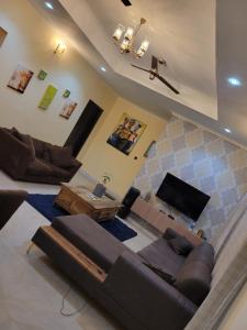 a living room with a couch and a television at AVIEL HOME in Accra