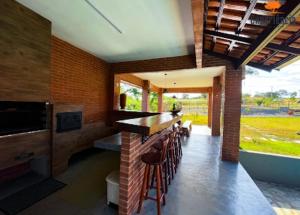 a kitchen with a counter and a bar with stools at Chácara Galileia in Trindade