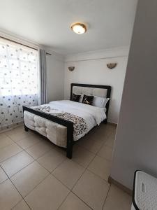 a bedroom with a bed and a window at Cosmic home in Thika
