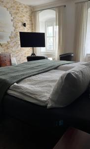 a large bed in a bedroom with a brick wall at Schloss1611 B&B in Erbendorf