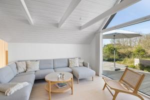 a living room with a couch and a table at Holiday Home Overlooking Ebeltoft Bay in Ebeltoft
