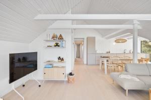 a white living room with a couch and a table at Holiday Home Overlooking Ebeltoft Bay in Ebeltoft +7 photos