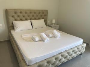 a large white bed with two pillows on it at Santa Saranda Villas in Pllakë