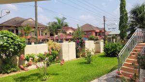a yard with a fence and some houses at AVIEL HOME in Accra
