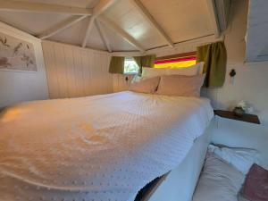a large white bed in a small room at Surf Shack on Broadway in Waitara
