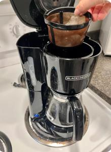 a person is making coffee in a coffee maker at Studio moderne et tranquille in Montreal