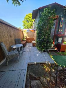 a wooden deck with a table and chairs in a backyard at Surf Shack on Broadway in Waitara