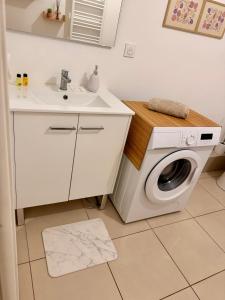 a bathroom with a washing machine and a sink at T2 neuf Parking privé Balcon Plages à 15 min in Montpellier