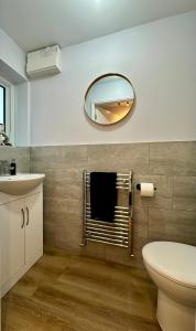 a bathroom with a mirror and a toilet and a sink at Serviced Accommodation, 3 Bed, allocated off road parking, Contractor Ready in Bedford