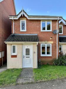 a red brick house with a white door at Serviced Accommodation, 3 Bed, allocated off road parking, Contractor Ready in Bedford