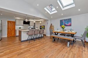 a dining room and kitchen with a table and chairs at CONTRACTOR FRIENDLY-Large Driveway-THREE SMART TV's-Central Location-FOUR DOUBLE BEDROOMS in Luton