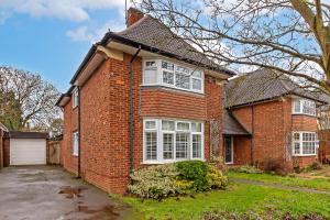 a brick house with white windows and a driveway at CONTRACTOR FRIENDLY-Large Driveway-THREE SMART TV's-Central Location-FOUR DOUBLE BEDROOMS in Luton +28 photos