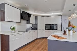 a kitchen with white cabinets and a white counter top at CONTRACTOR FRIENDLY-Large Driveway-THREE SMART TV's-Central Location-FOUR DOUBLE BEDROOMS in Luton