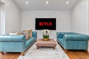 a living room with two blue couches and a table at CONTRACTOR FRIENDLY-Large Driveway-THREE SMART TV's-Central Location-FOUR DOUBLE BEDROOMS in Luton