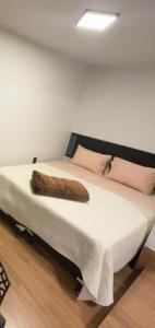 a bed with a wooden log on top of it at 4 Studio novo no centro com ar condicionado e tv UFLA, UNILAVRAS restaurantes padaria in Lavras
