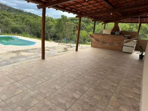 an outdoor patio with a grill and a pool at Rancho Patrocínio in Patrocínio