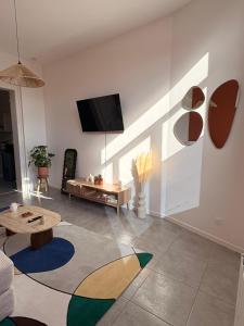 a living room with a tv on a wall at L'atelier Terracotta centre ville Bethune in Béthune