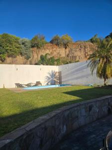 a retaining wall with a palm tree in a park at Premium house with pool in Santana do Livramento