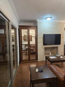 a living room with a couch and a flat screen tv at Premium house with pool in Santana do Livramento