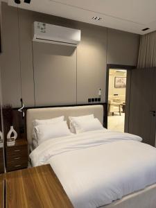 a bedroom with a large white bed with white sheets at فيلا شاليه ذا ويسس in Taif +12 photos
