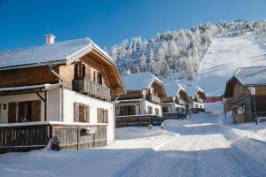 a group of wooden buildings in the snow at Almdorf Katschberg in Katschberghöhe