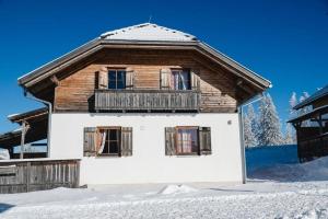 a wooden house in the snow with snow at Almdorf Katschberg in Katschberghöhe