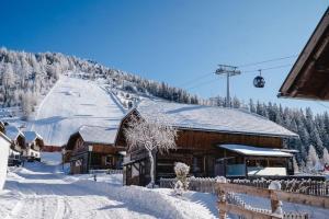 a ski lodge in the snow with a ski lift at Almchalet am Katschberg in Katschberghöhe