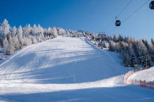 a snow covered ski slope with a ski lift at Almchalet am Katschberg in Katschberghöhe