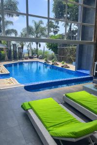 a large swimming pool with green cushions in a building at The View on Nyle Rustenburg in Rustenburg