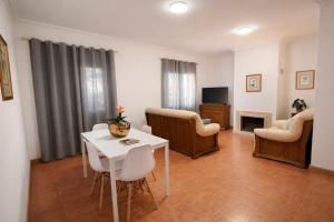 a living room with a table and chairs and a tv at Casa do Paraíso in Elvas +2 photos