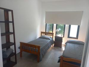 a bedroom with a bed and a chair and a window at Muana Escobar in Belén de Escobar +31 photos