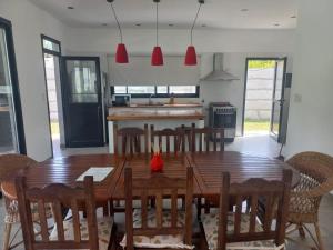 a kitchen and dining room with a wooden table and chairs at Muana Escobar in Belén de Escobar