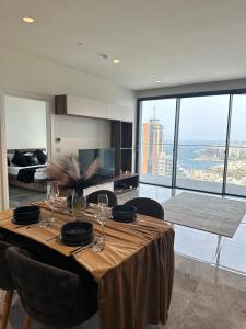 a dining table in a room with a view of the ocean at Whispering Waves at Mercury Tower with panoramic view , 2X pools and Gym in Paceville