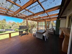 a covered deck with a ping pong table and a grill at All decked out in Rotorua