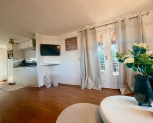a living room with a vase of flowers on a table at Ermrest Cottage in Erm +8 photos